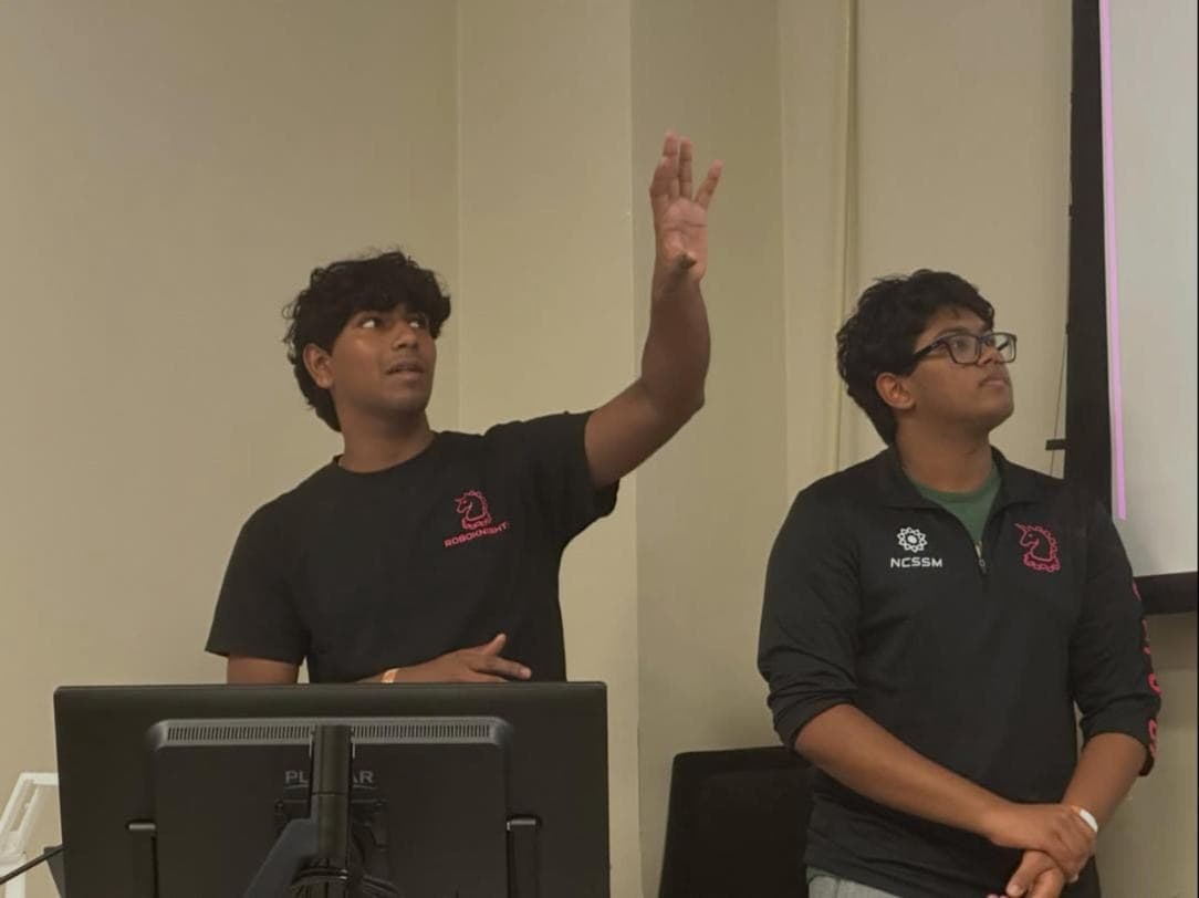 Two RoboKnights presenters at the podium during the Mechanical Optimization talk