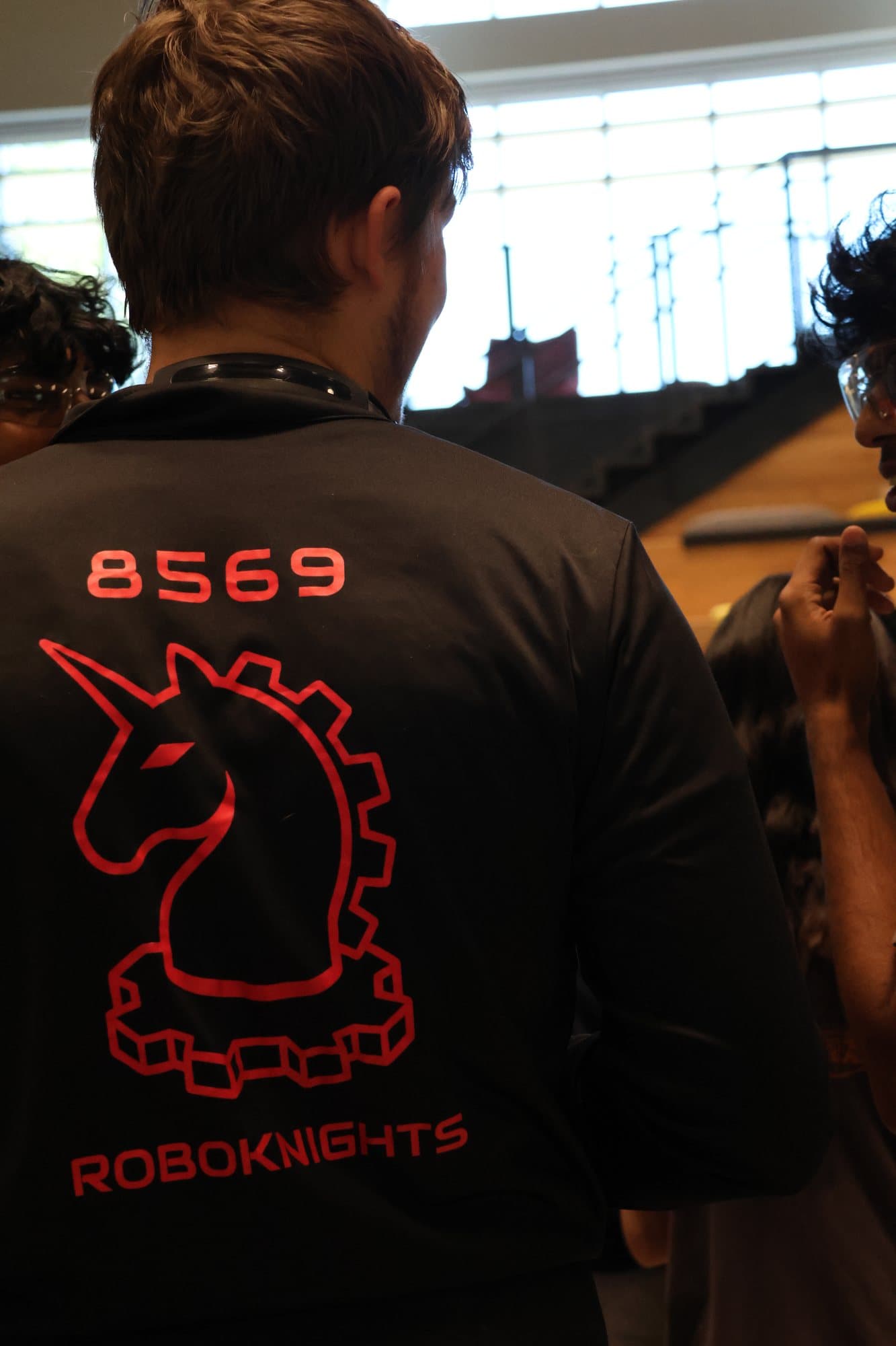 A RoboKnights member in an 8569 shirt watching the field