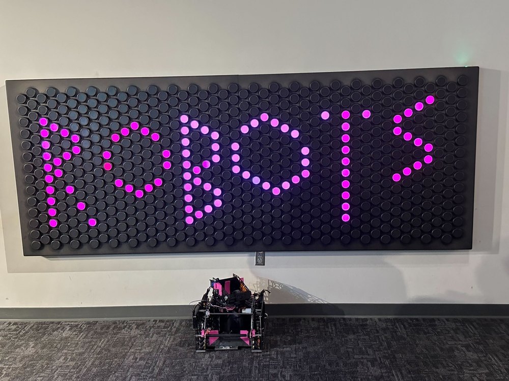 The robot under the ROBOTS sign at the museum